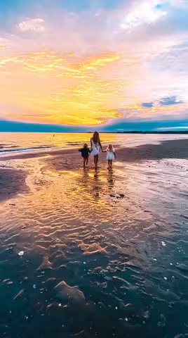 siblings walking along the beach