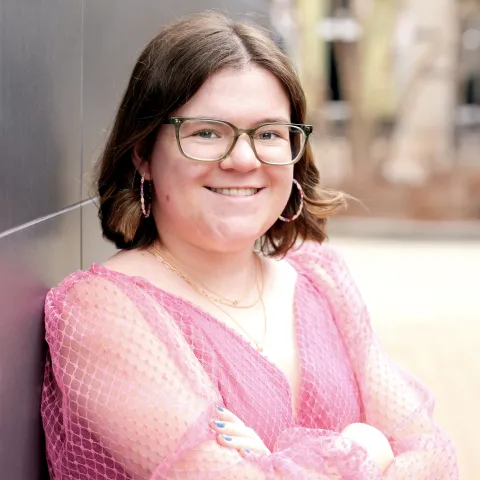 Caitlyn Grad headshot in pink shirt.