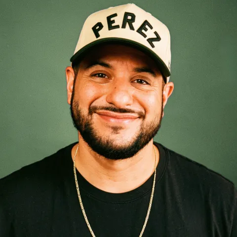 Mike Perez aka @justPEREZplay wearing a PEREZ embroidered hat and black t-shirt.