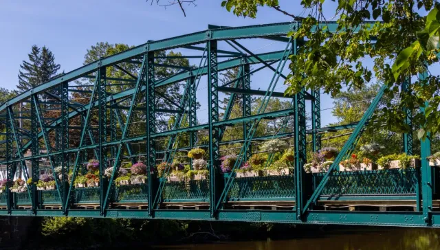 metal truss bridge lined with flowers