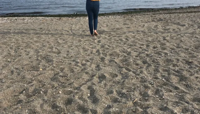 woman on beach walking toward water