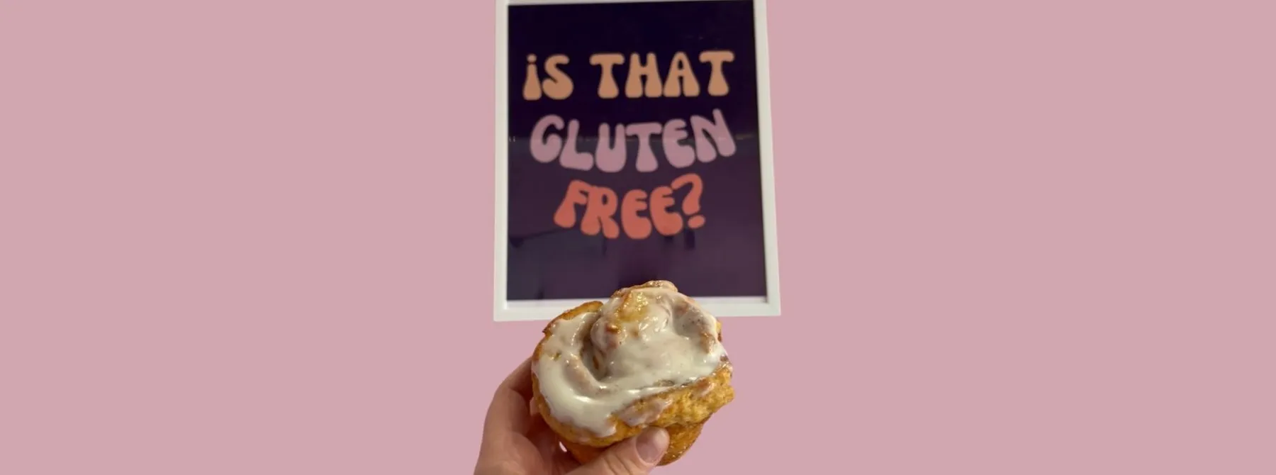 Cinnamon roll in front of a sign that says "is that gluten free?"