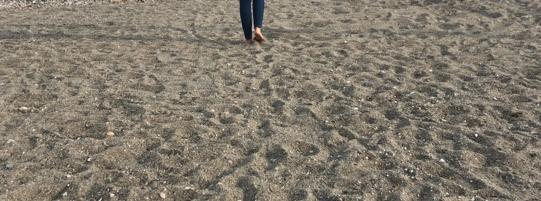 woman on beach walking toward water