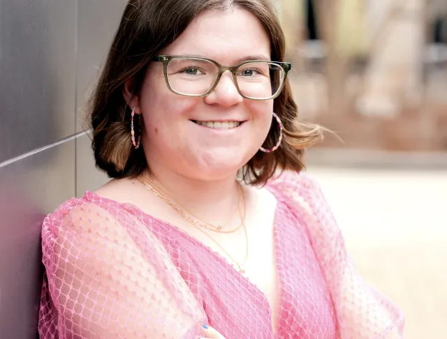 Caitlyn Grad headshot in pink shirt.