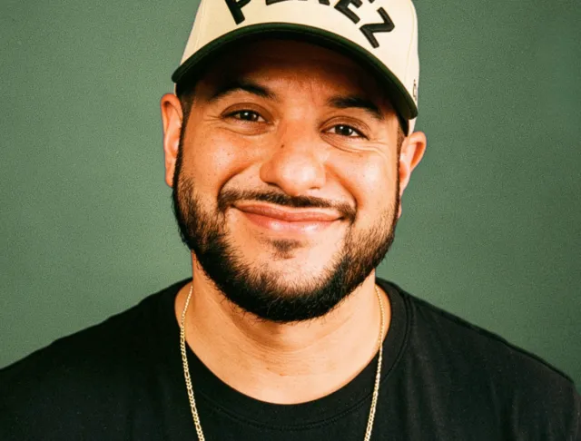 Mike Perez aka @justPEREZplay wearing a PEREZ embroidered hat and black t-shirt.